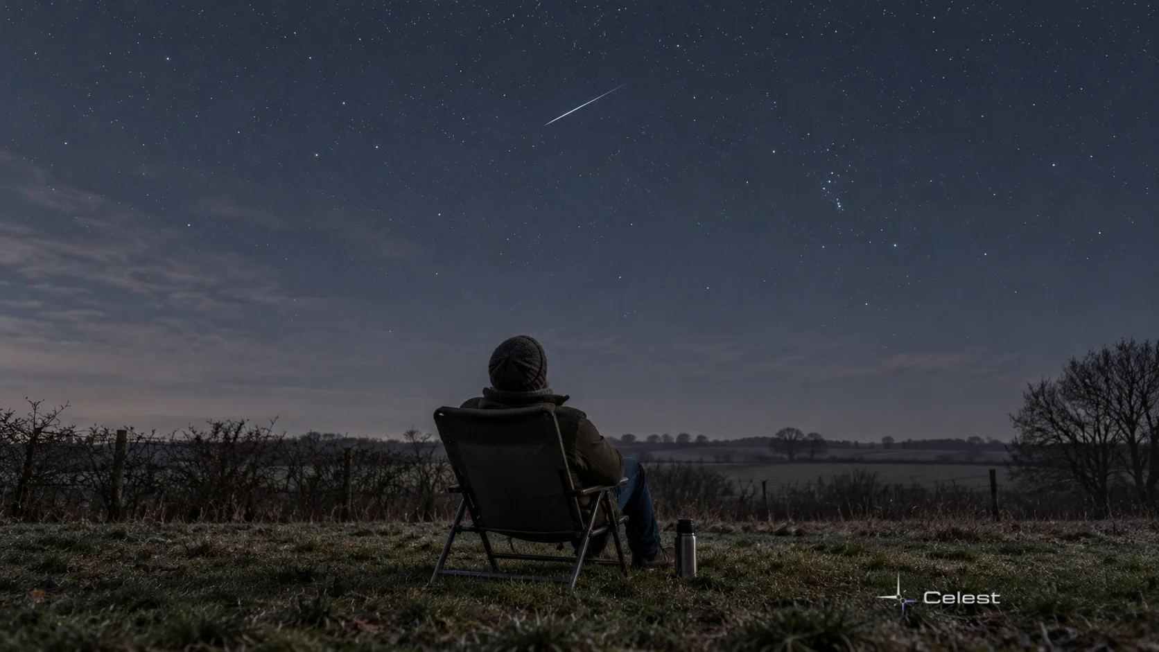 A warmly dressed observer watches one thin meteor above a quiet late-autumn rural landscape.